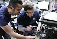 Lernen von dem Besten: Amjad Al Hamwi (links) schaut seinem Kollegen Matthias Koch bei der Reparatur eines Kaffeevollautomaten &uuml;ber die Schulter. - Achim Krause