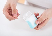 Frau benutzt Zahnseide - Christin Klose/dpa-tmn