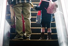 Mädchen steht neben ihrem Vater auf einer Rolltreppe - Diego Azubel/epa/dpa-tmn