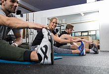 Junge Menschen dehnen beim Sport die Beine - Christin Klose/dpa-tmn