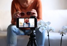 Influencerin folmt sich mit Sonnenbrille in den Händen - Karl-Josef Hildenbrand/dpa/dpa-tmn