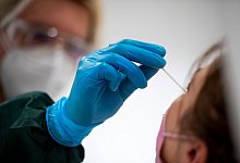 Eine Frau wird in einem Testzentrum auf das Coronavirus getestet. - Christophe Gateau/dpa