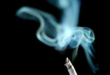Brennende Zigarette mit Rauchwolke - Foto: Karl-Josef Hildenbrand/dpa/dpa-tmn