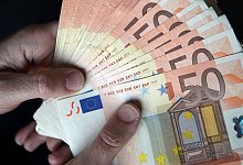 Person hält Geldscheine in den Händen - Jan Woitas/dpa/dpa-tmn