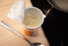 Ge&ouml;ffneter Becher Schmand steht in einer K&uuml;che - Christin Klose/dpa-tmn