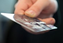 Eine Frau hält eine Bankkarte - Andrea Warnecke/dpa-tmn