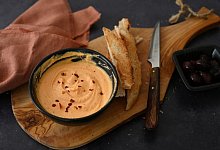 Eine Schale mit Fetacreme steht auf einem Holzbrett - Julia Uehren/dpa-tmn