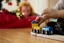 Ein Kind spielt mit einer Holzeisenbahn - Christin Klose/dpa-tmn