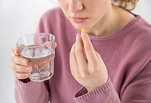 Eine Frau nimmt eine Kapsel ein - Christin Klose/dpa-tmn