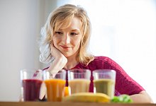 Eine Frau sitzt vor gef&uuml;llten Gl&auml;sern - Christin Klose/dpa-tmn