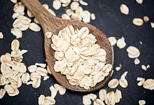 Haferflocken auf einem Holzlöffel - Andrea Warnecke/dpa-tmn