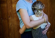 Ein M&auml;dchen wird von seiner Mutter in den Arm genommen - Annette Riedl/dpa/dpa-tmn