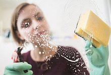 Frau putzt die Dusche im Badezimmer - Franziska Gabbert/dpa-tmn