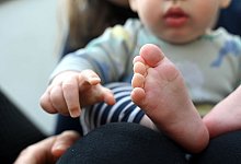 Baby auf dem Schoß seiner Mutter - Elisa Schu/dpa