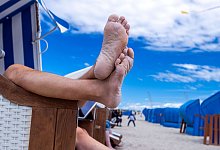 Urlauber sitzen in einem Strandkorb - Jens Büttner/dpa/dpa-tmn