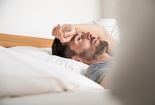 Mann liegt schlaflos im Bett - Christin Klose/dpa-tmn