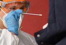 Ein Mitarbeiter nimmt einen Abstrich von einer Patientin f&uuml;r einen PCR-Test. - Julian Stratenschulte/dpa