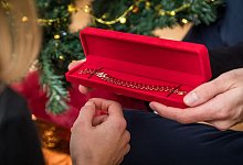 Eine Person überreicht einer anderen ein Geschenk - Christin Klose/dpa-tmn