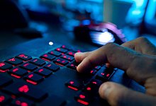 Ein Mann sitzt am Rechner und tippt auf einer Tastatur - Nicolas Armer/dpa