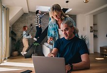 Ein Mann und eine Frau blicken auf einen Laptop - Zacharie Scheurer/dpa-tmn