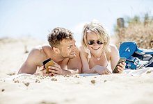 Ein Paar liegt am Strand - Christin Klose/dpa-tmn