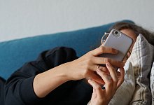 Frau mit Handy - Weronika Peneshko/dpa