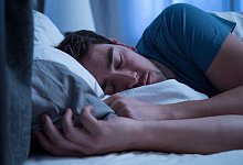 Mann schläft in einem Bett - Christin Klose/dpa-tmn