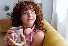 Frau schaut entspannt aus dem Fenster - Cocoon Studio/Westend61/dpa-tmn