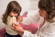 Mädchen bekommt beim Kinderarzt ein Pflaster auf den Arm - Christin Klose/dpa Themendienst/dpa-tmn