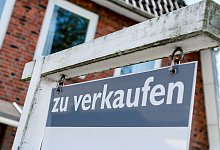 Ein Schild mit der Aufschrift "zu verkaufen" steht vor einem Haus - Markus Scholz/dpa-tmn