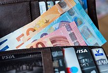 Banknoten und Bankkarten liegen in einer Geldb&ouml;rse - Monika Skolimowska/dpa/dpa-tmn