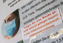 Ein Aufkleber mit der Aufschrift „Tragen Sie eine Maske gemäß aktuell gültiger bayerischer Infektionsschutzmaßnahmenverordnung“ ist an einem Hinweisschild im Amtsgericht in München zu sehen. - Peter Kneffel/dpa