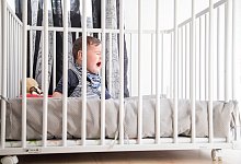 Kind im Gitterbett - Foto: Christin Klose/dpa-tmn