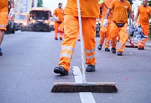 Mitarbeiter einer Stadtreinigung s&auml;ubern eine Stra&szlig;e. - Annette Riedl/dpa/Symbolbild