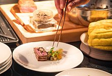 Ein Koch richtet sein Gericht auf einem Teller an - Christin Klose/dpa-tmn