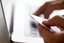 Eine Person mit Kreditkarte und Laptop - Franziska Gabbert/dpa-tmn