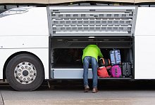 Person an Fernbus-Kofferraum - Alexander Heinl/dpa-tmn/dpa