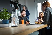 Kollegen sitzen in einer Pause zusammen - Christin Klose/dpa-tmn