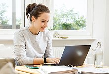 Eine junge Frau arbeitet an einem Laptop - Christin Klose/dpa-tmn