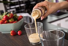 Eine Frau gießt ein Fertig-Getränk in ein Glas - Christin Klose/dpa-tmn