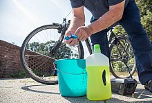 Jemand putzt sein Rad mit Tuch, Wasser und Reiniger. - Christin Klose/dpa-tmn/dpa