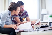 Paar schaut in einen Stapel Unterlagen - Christin Klose/dpa-tmn