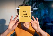 Eine Frau hält ein Buch an eine Glasscheibe - Joseffson/Westend61/dpa-tmn