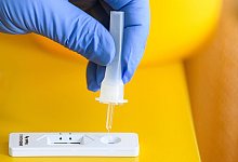 Eine Frau tr&auml;ufelt die L&ouml;sung eines Corona-Schnelltest auf die Testkassette. - Robert Michael/dpa-Zentralbild/dpa