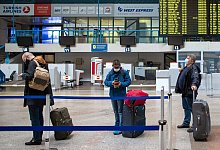 Reisende am Flughafen - Foto: Mindaugas Kulbis/AP/dpa