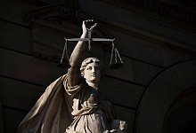 Vor einem Justizgebäude steht die Statue der Justitia - Stefan Puchner/dpa/dpa-tmn