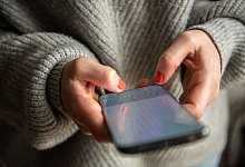 Person mit lackierten Fingern&auml;geln h&auml;lt Smartphone in den H&auml;nden - Zacharie Scheurer/dpa-tmn