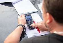 Ein Mann arbeitet am Taschenrechner - Silas Stein/dpa