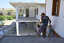 Till Rautert und die Zwillinge Tao und Doa gehen vorbei an den H&auml;usern, die nach den Waldbr&auml;nden im Juli 2021 neu aufgebaut werden. - Anne Pollmann/dpa