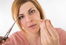 Eine Frau h&auml;lt Schere und abgeschnittene Haare in den H&auml;nden. - Christin Klose/dpa-tmn